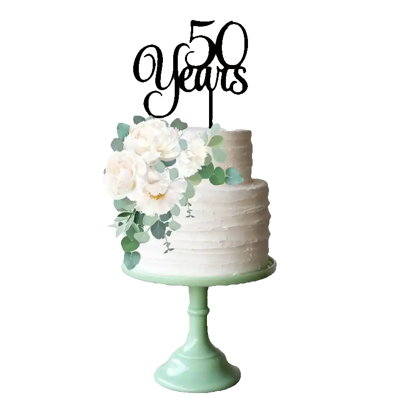 A two-tier white cake topped with a black ‘50 Years’ acrylic cake topper, adorned with white peonies and greenery on a mint stand. Birthday Gifts in the UAE
