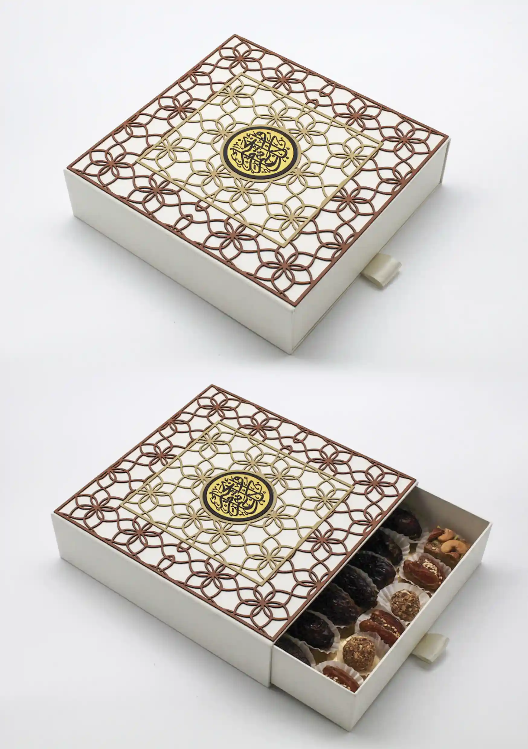 Intricately designed white gift box with layered gold and brown Islamic patterns and a central medallion, opened to reveal assorted premium dates