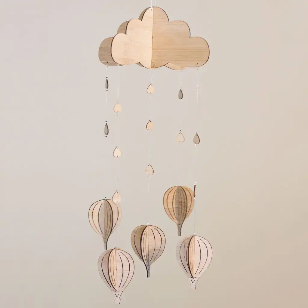 A hanging nursery mobile featuring a layered wooden cloud, raindrops, and 3D hot air balloons suspended by clear strings