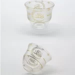 Frosted glass cups adorned with gold Arabic calligraphy and ornate designs for Ramadan celebrations