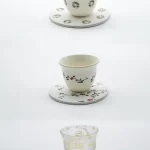 A trio of Arabic coffee cups and matching coasters, each decorated with intricate Islamic patterns and Ramadan greetings