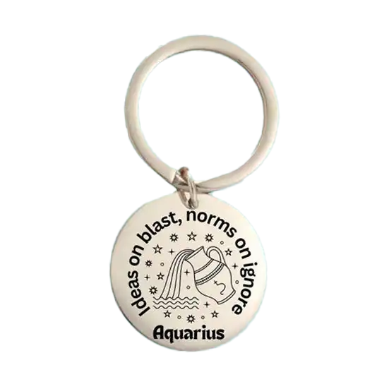 A round metal keychain showcasing an Aquarius zodiac illustration and a playful quote, displayed against a soft teal background. Birthday Gifts in the UAE