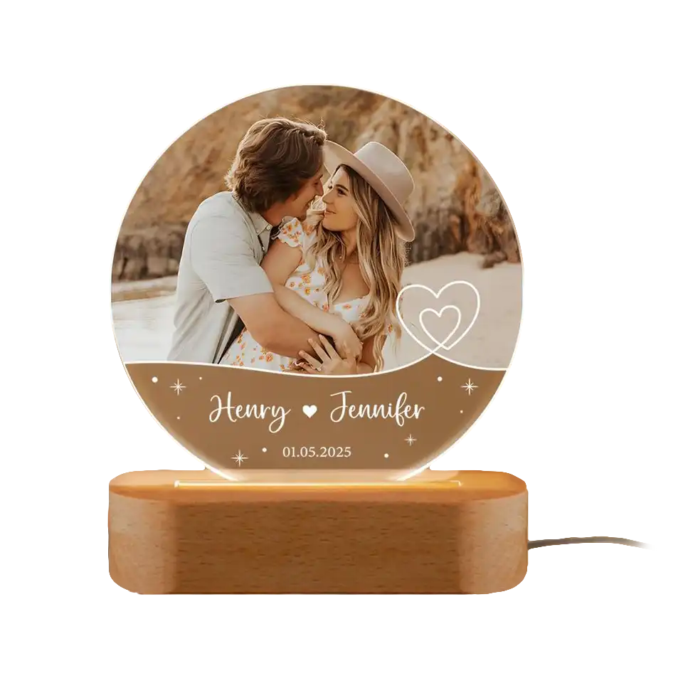 A circular acrylic LED lamp on a wooden base, displaying a couple’s photo, their names Henry and Jennifer, and a special date