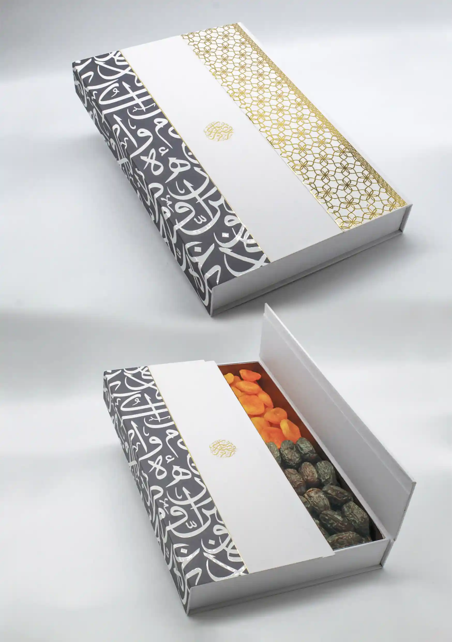 White cardboard gift box adorned with black Arabic calligraphy and a gold geometric accent strip, open to display dried fruits