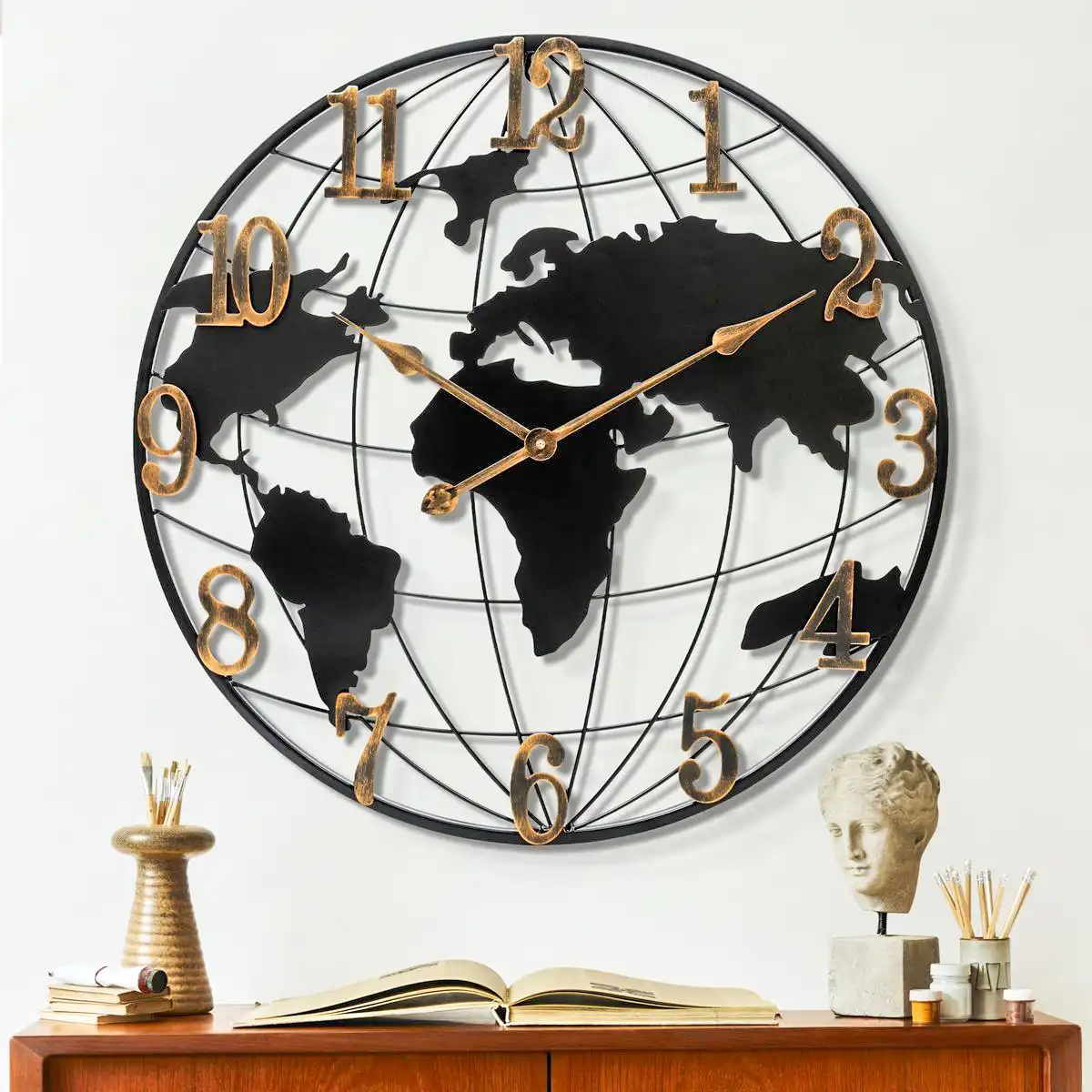 round-metal-world-map-clock-office-decor A large circular wall clock featuring a black metal world map design and gold numerals, displayed above a desk.