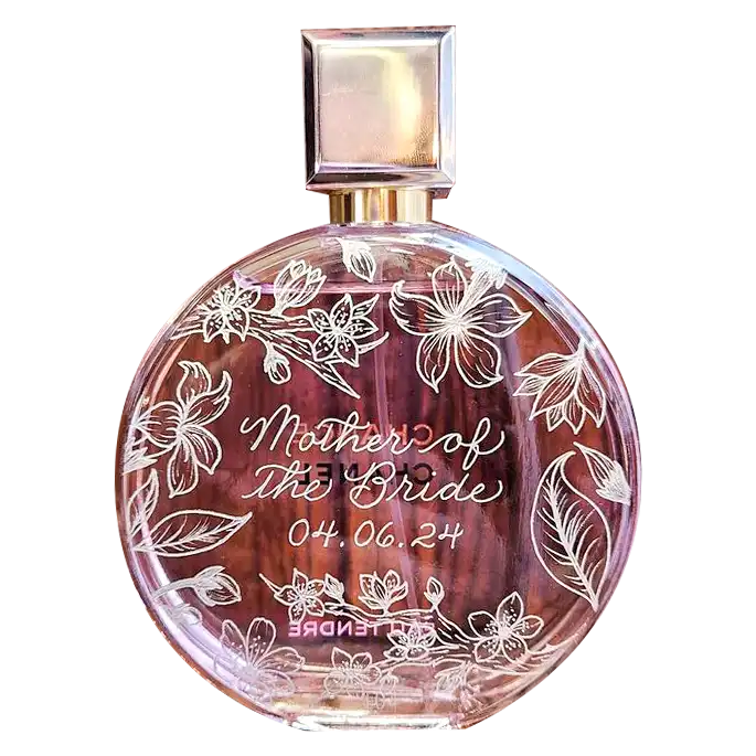 A round transparent perfume bottle etched with floral designs and the inscription Gifts for Women