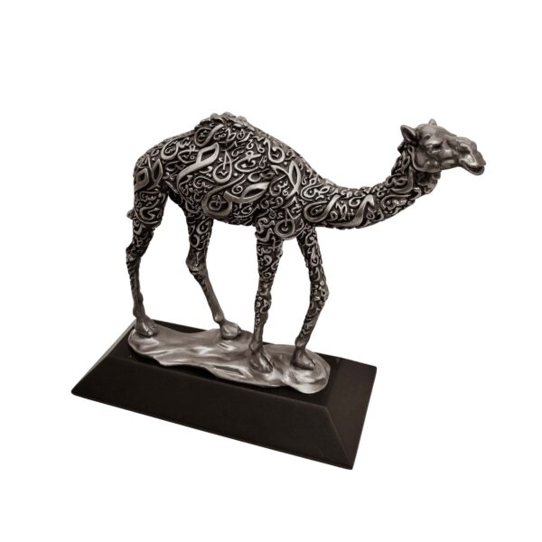 Antique silver camel sculpture with intricate Arabic calligraphy on body, standing on a flat base.