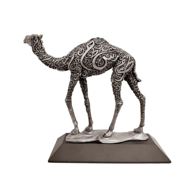 Antique silver camel sculpture with intricate Arabic calligraphy on body, standing on a flat base.