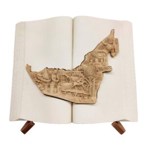 3D UAE map sculpture in an open book with bas-relief landmarks and a wooden display stand.