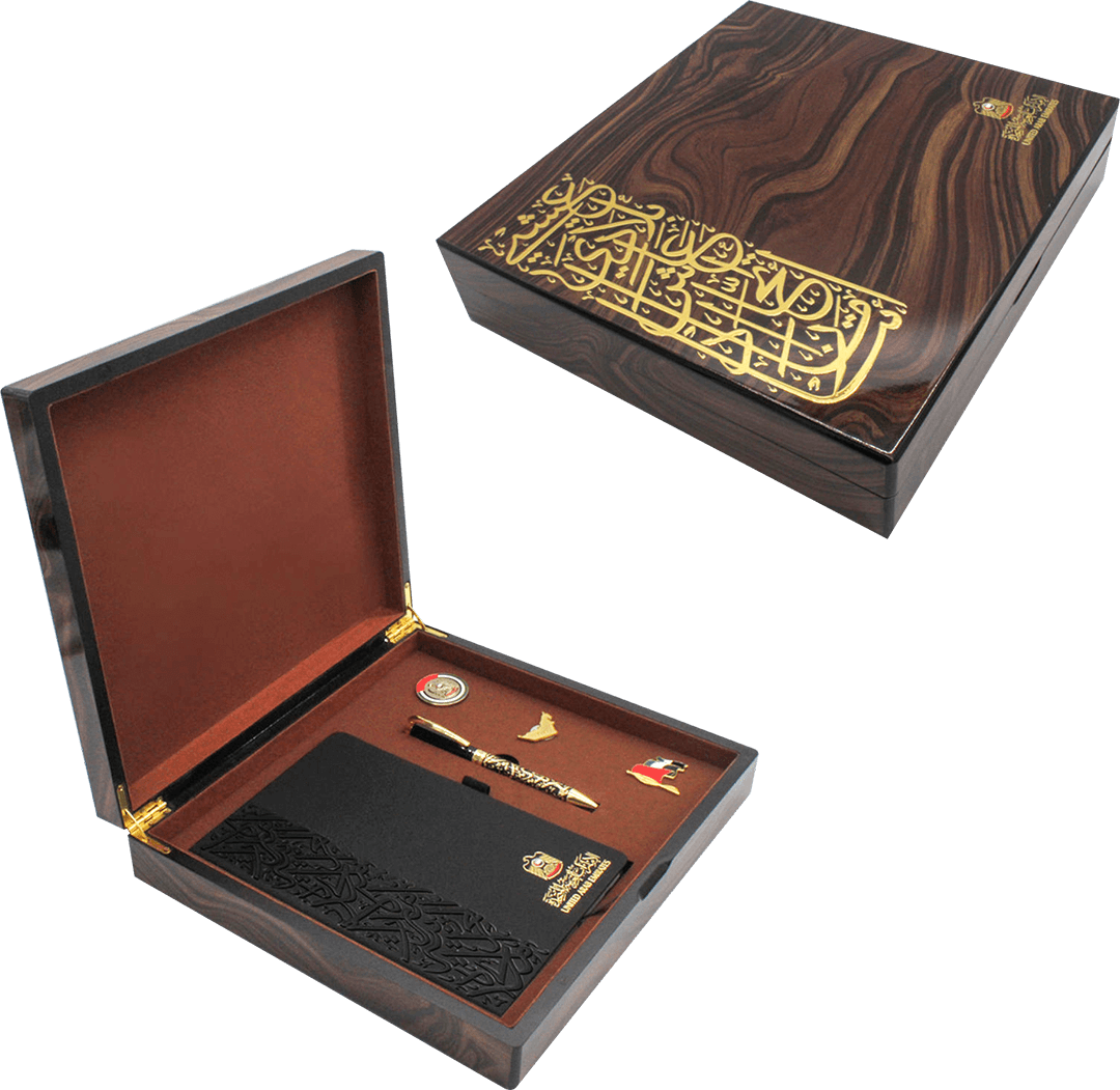 Vintage wooden VIP gift box with gold Arabic calligraphy, featuring a notebook, pen, and UAE-themed badges — part of the UAE National Day Gifts 2025 collection.