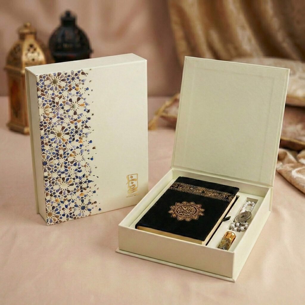 White luxury gift box containing a black velvet Quran with gold text and white prayer beads.