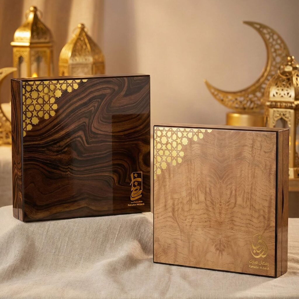 Polished high-gloss wooden gift box with swirled burl wood grain and gold Islamic geometric corner detail.