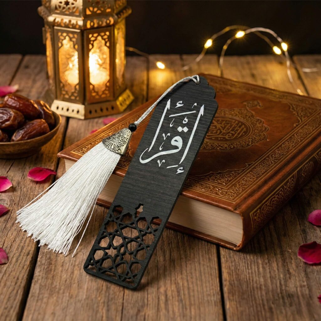 Black wooden bookmark with white Arabic calligraphy "Iqra" and white tassel on a Quran.