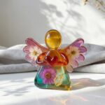 Custom colored epoxy resin angel figurine with embedded dried flowers and a red heart.