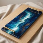 Rectangular colored epoxy resin serving tray with gold handles featuring a swirling deep blue and white marble pattern.