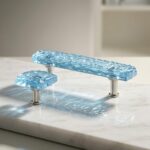 A rectangular drawer pull and matching square knob made of translucent blue textured epoxy resin on silver hardware.